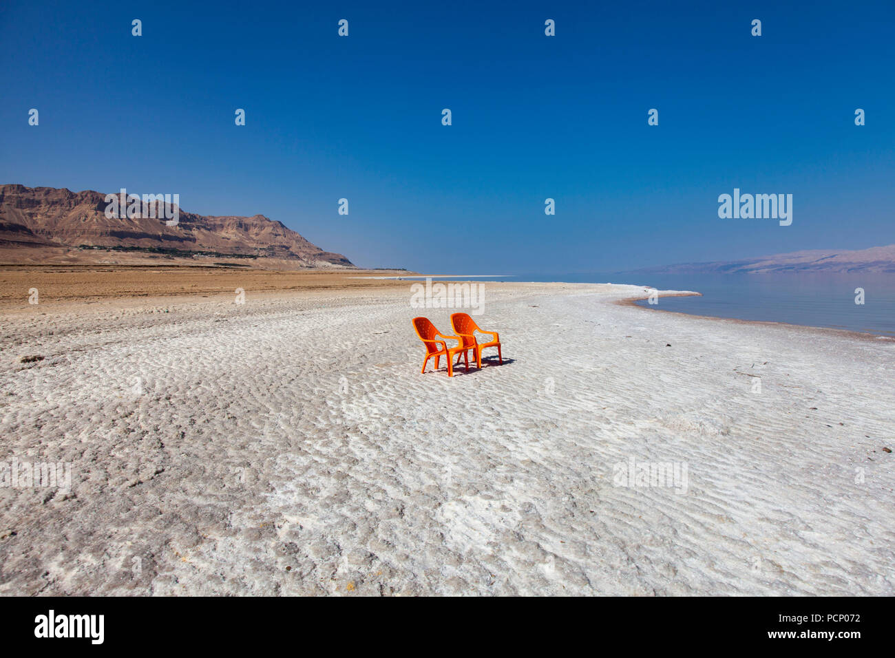 Israel, En Gedi Spa, two orange chairs on halite deposits of the Dead Sea Stock Photo