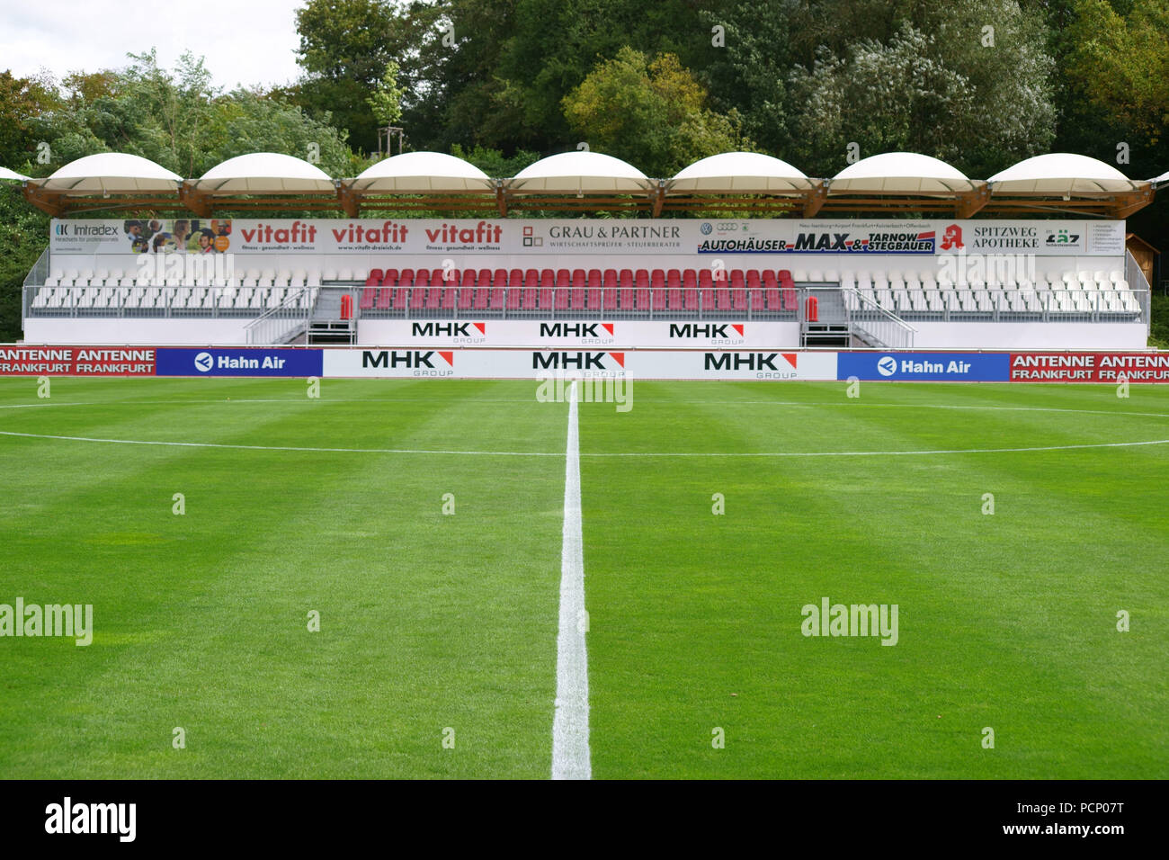 The covered grandstand of Hahn Air Sportpark with advertising boards and banners in Dreieich. Stock Photo