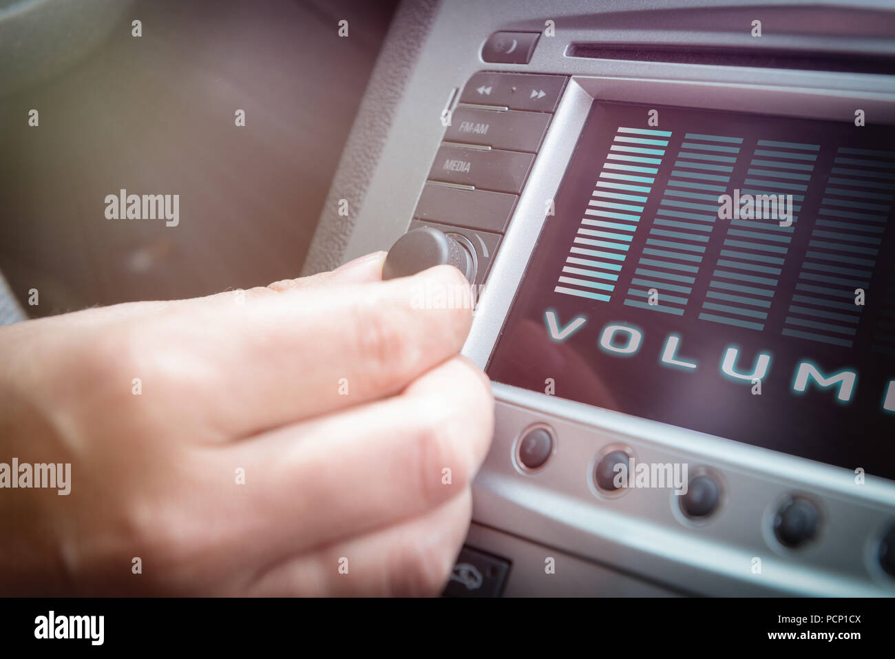 Driver using knob to adjust volume in the car audio system Stock Photo