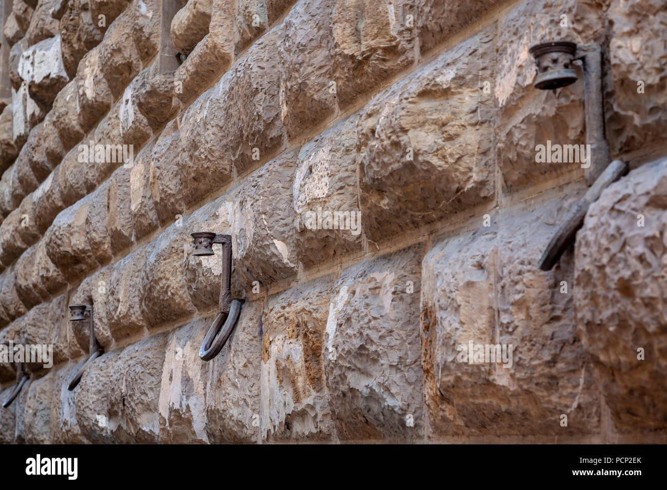 A rustic bossage wall of the Medici Riccardi Palace, at Florence (1444 - 1459) keeping torch holders combined with horse rings. Stock Photo