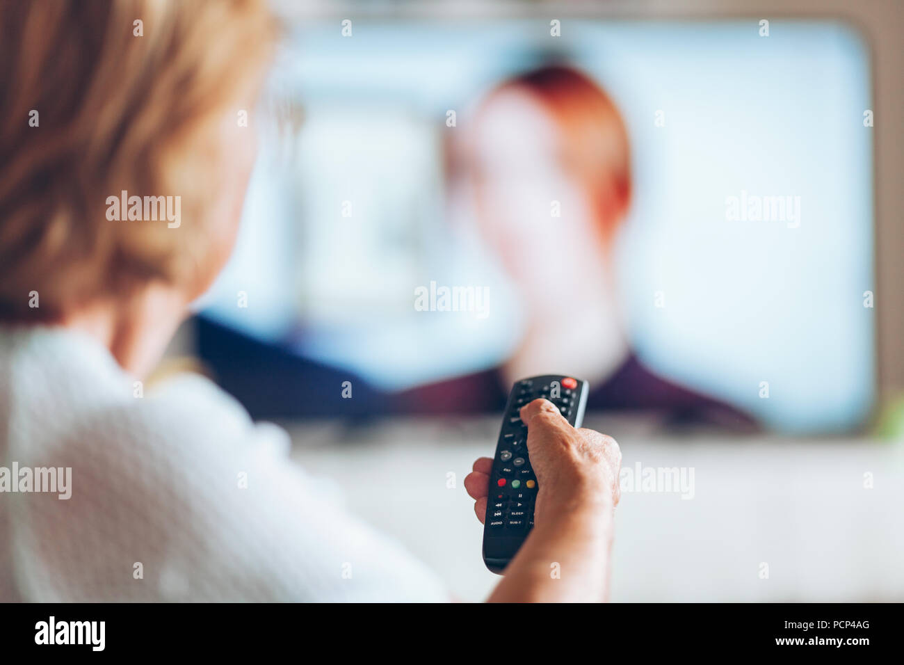 Senior woman with remote control watching television Stock Photo Alamy