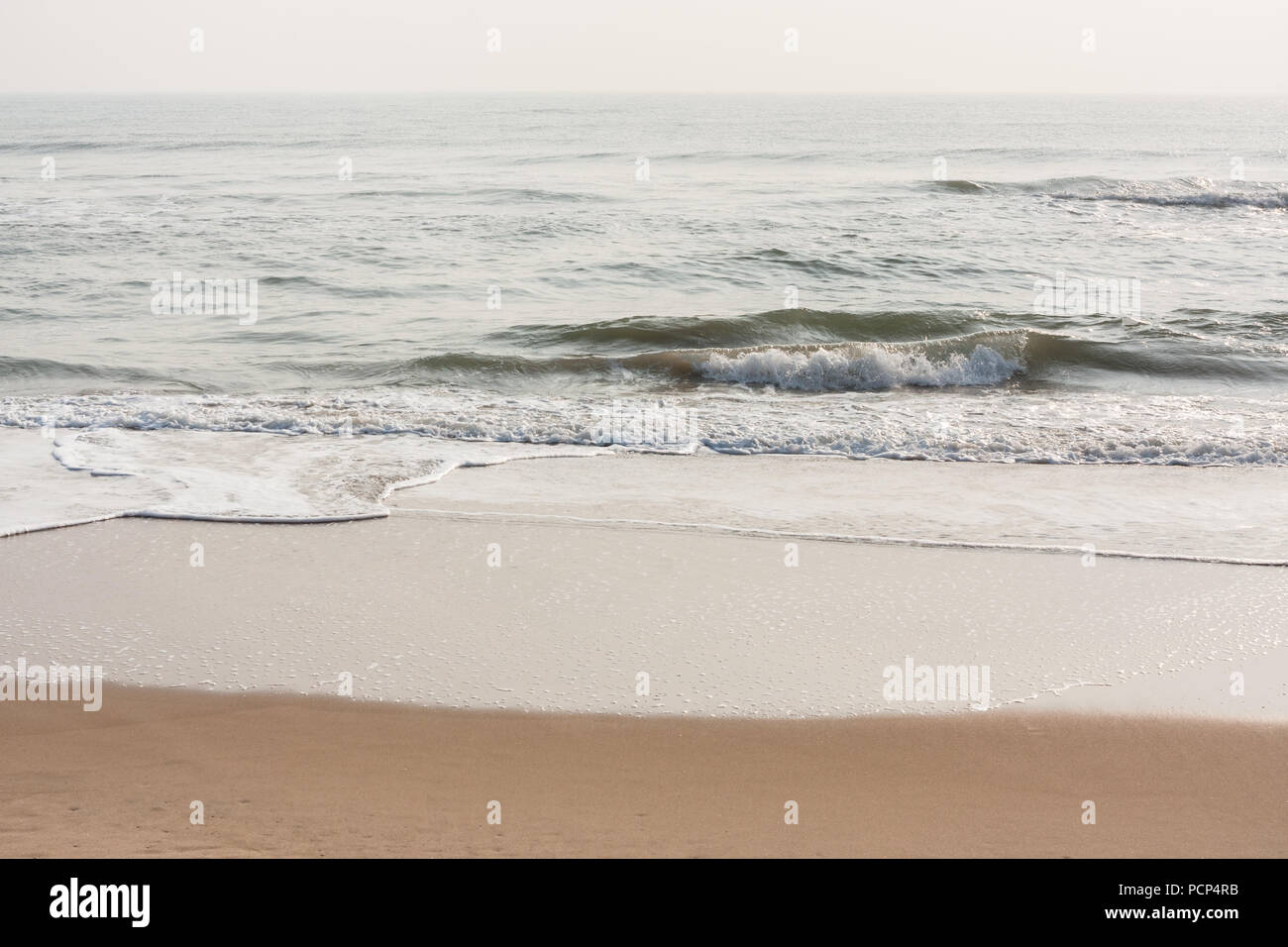Foamy waves on calm beach Foamy sea waves on a calm tropical beach in