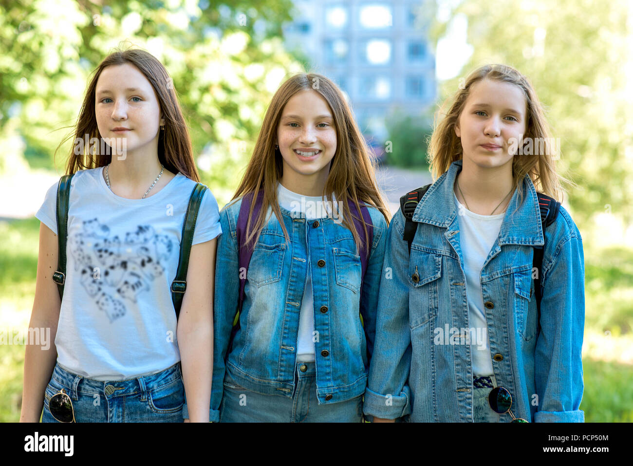 Three girl friends girl schoolgirl. Summer in nature. In jeans ...