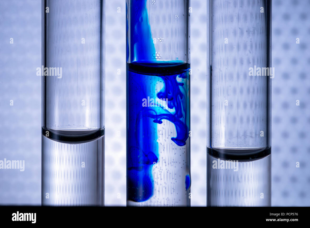 Closeup liquid of blue color ink in water in a test tube of vitro. Concept idea on a medical theme. Stock Photo