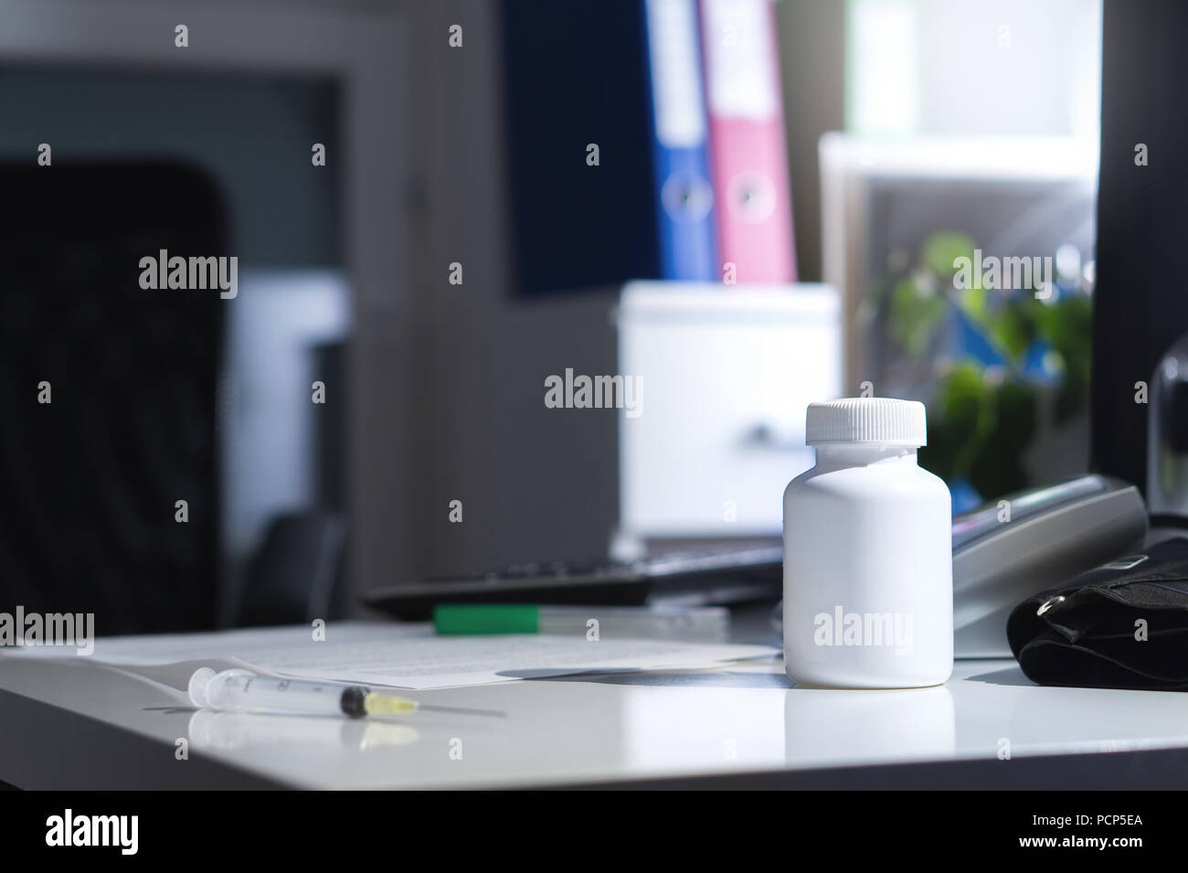 Malpractice, bad healthcare, negligence, medical fraud or abuse or treatment error concept. Medicine bottle on table and desk in doctor office. Stock Photo