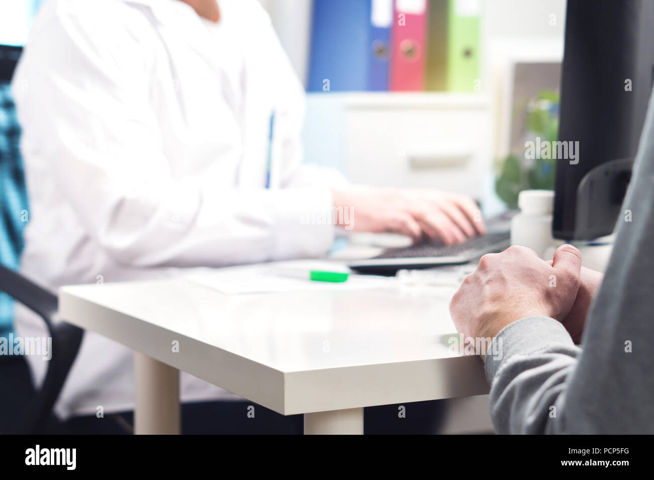 Doctor and patient in appointment, visit or meeting in hospital office or emergency room. Physician or nurse writing prescription or instructions. Stock Photo