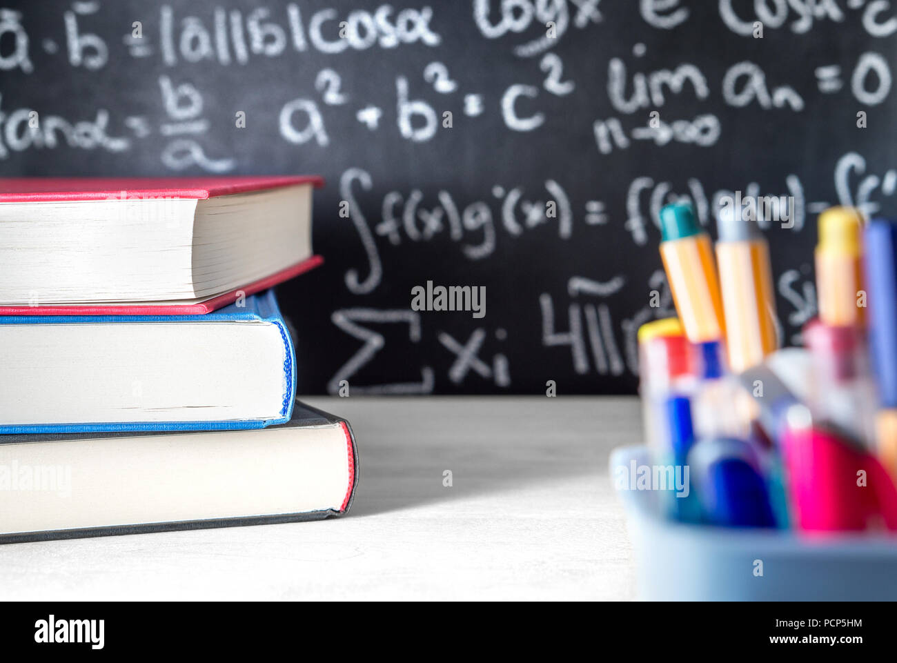 School supplies in classroom. Blackboard or chalkboard in class. Teaching, lesson, lecture and science concept. Stock Photo