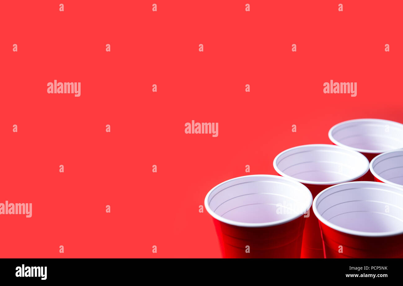 Red party cup and beer pong tournament background template. Alcohol containers with negative copy space. Stock Photo