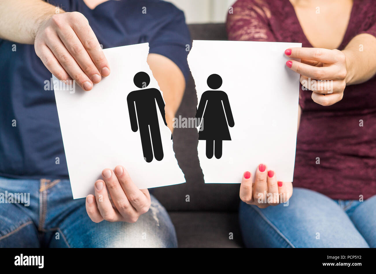 Break up, divorce and marital problems concept. Couple holding ripped pieces of paper with man and woman symbol. Stock Photo