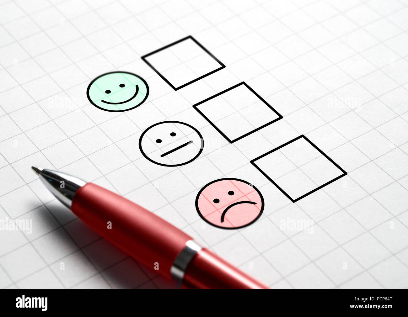 Customer satisfaction survey and questionnaire concept. Giving feedback with multiple choice form. Pen, paper and emotion smiley face icons. Stock Photo