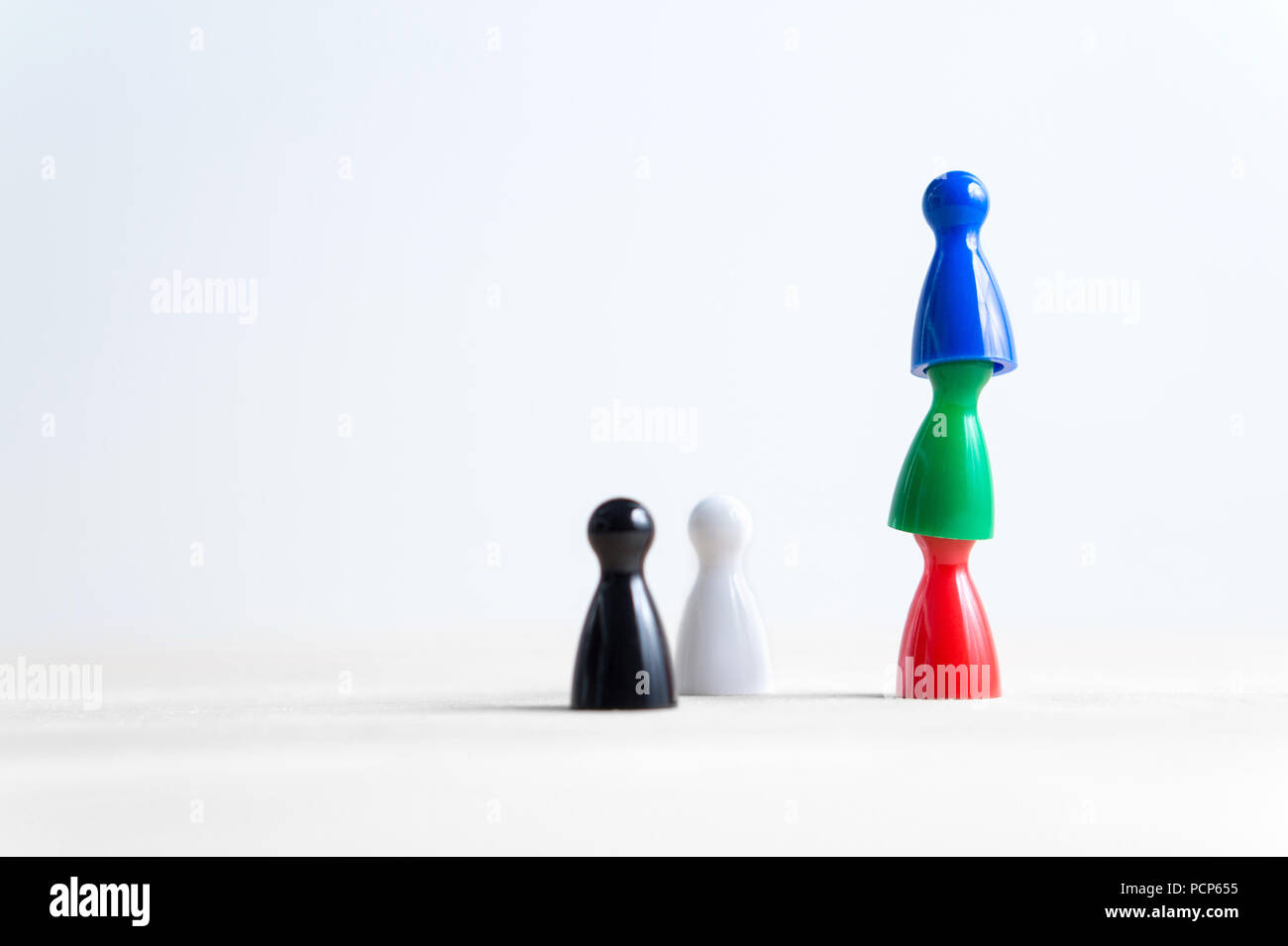 Teamwork, reaching goals, working together and success concept. Colorful board game pawns on each other. Cooperation, leadership and achievement. Stock Photo