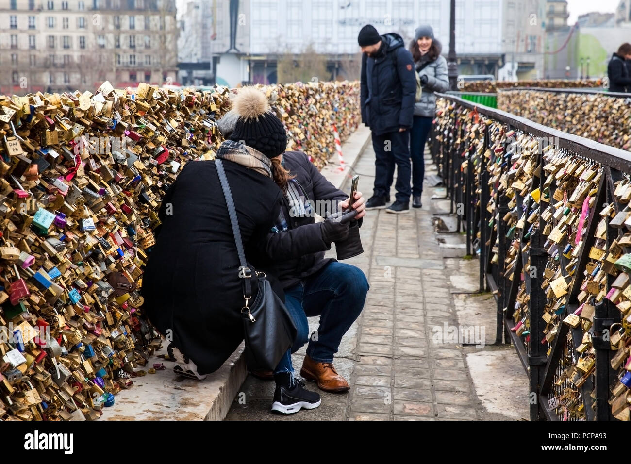 PARIS, FRANCE - MARCH, 2018: Couple taking a selfie at the Pont Neuf love locks in Paris Stock Photo