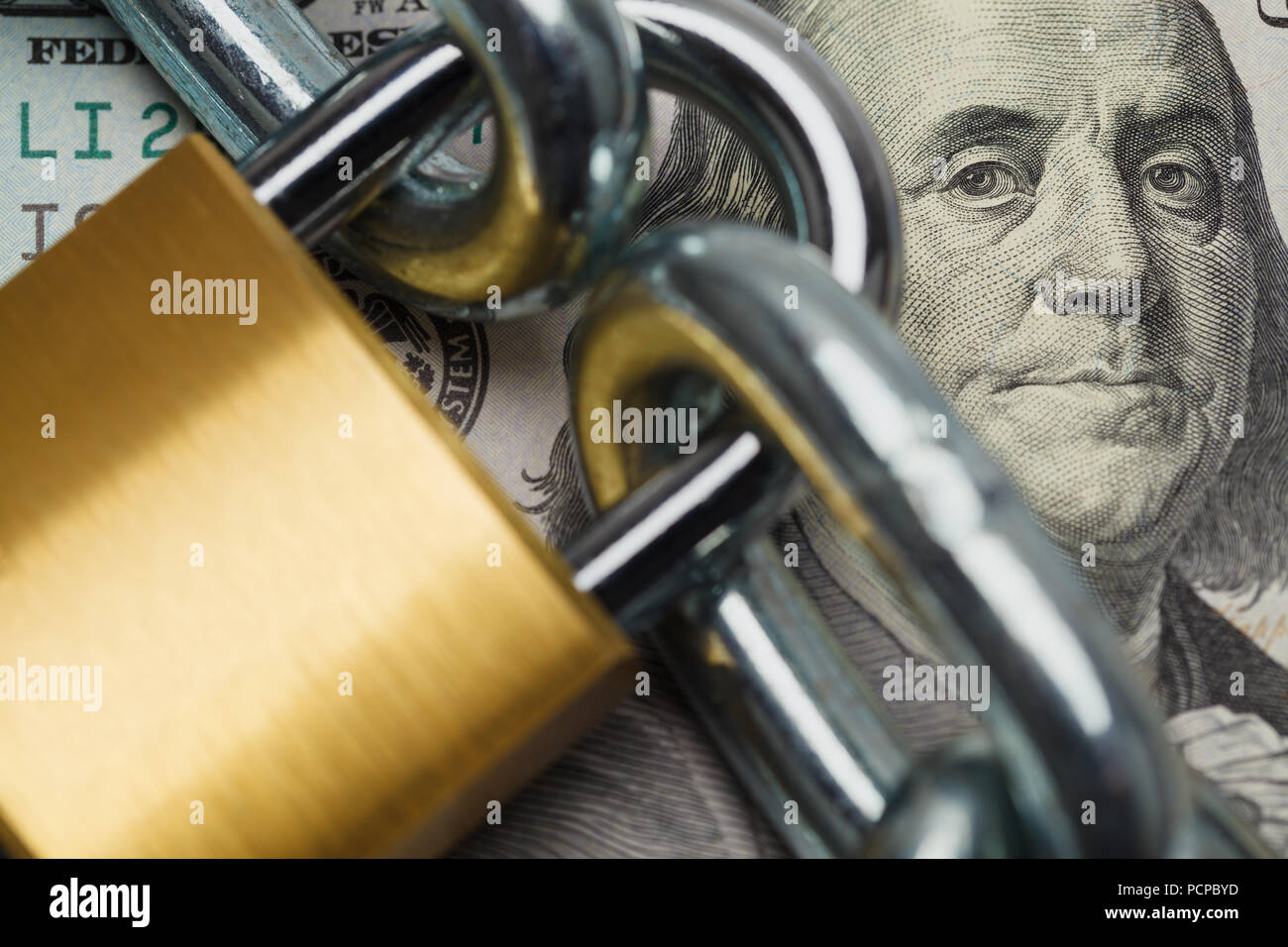 Close Up of Hundred Dollar Bill With Lock and Chain. Stock Photo