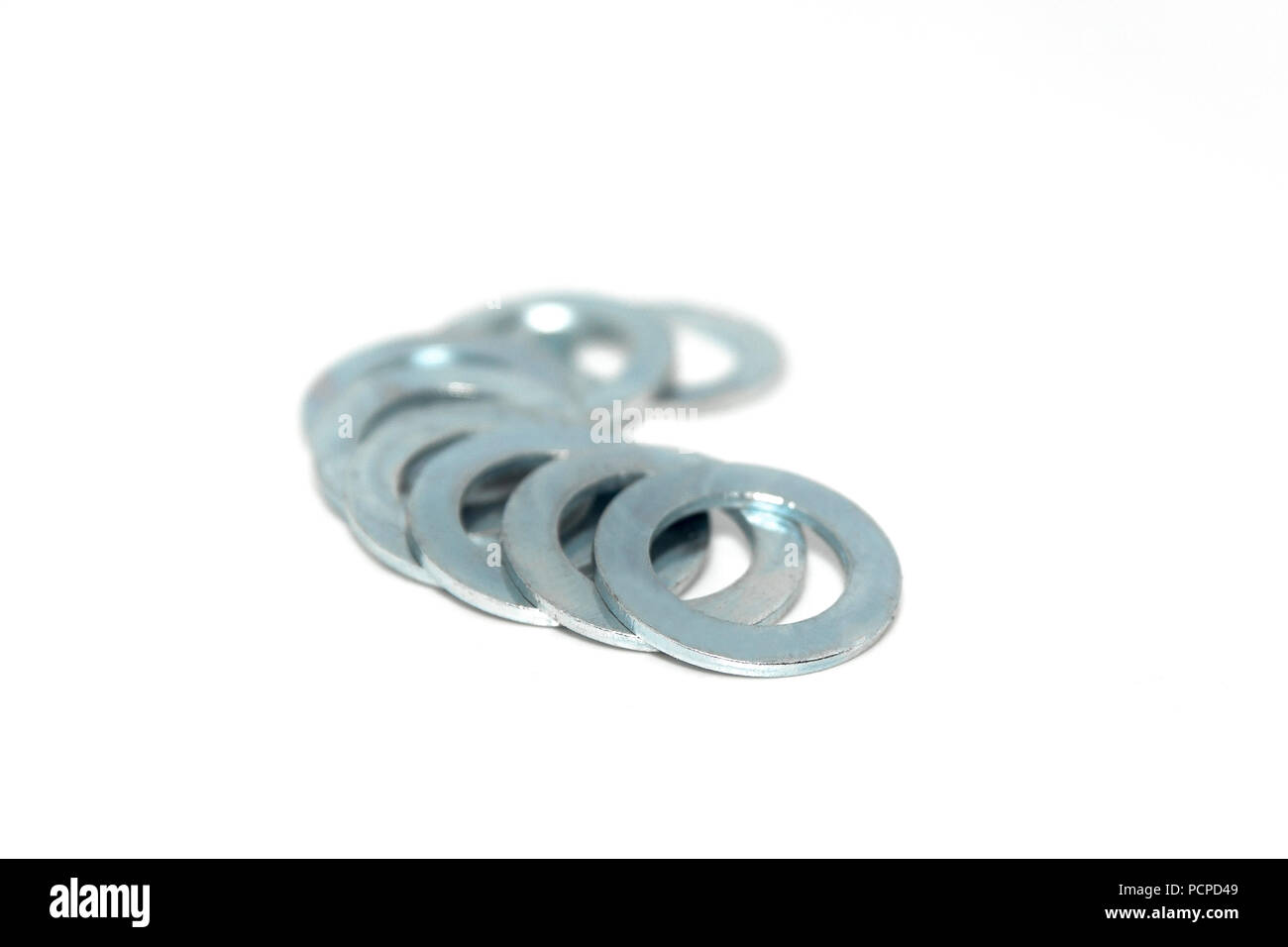 A few big industrial galvanized steel washers on white background Stock