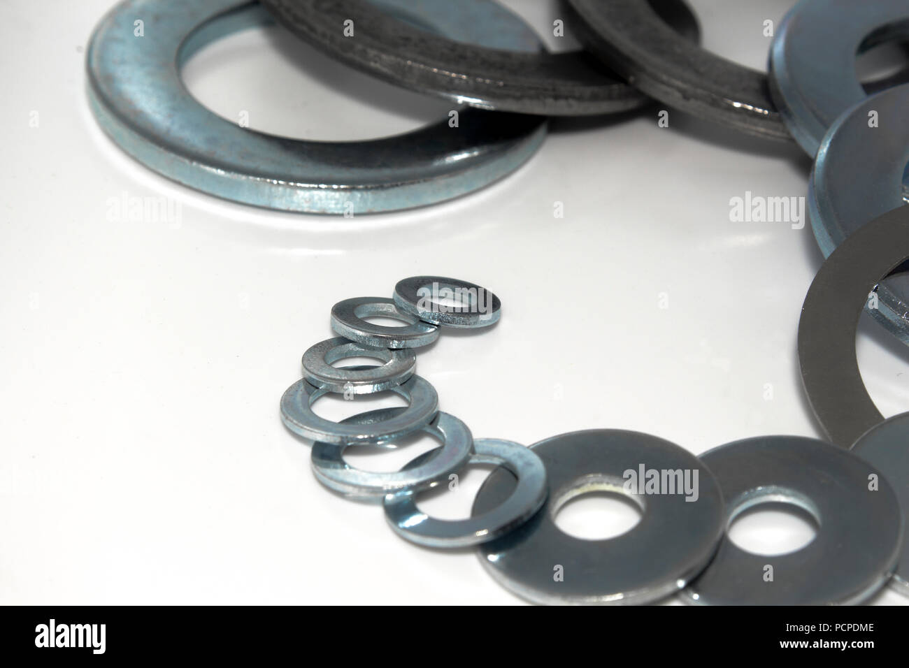 Variety of industrial galvanized steel washers on white background