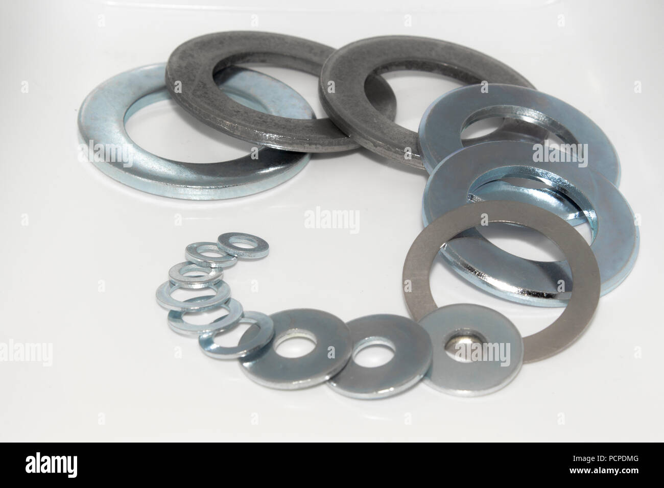 Variety of industrial galvanized steel washers on white background