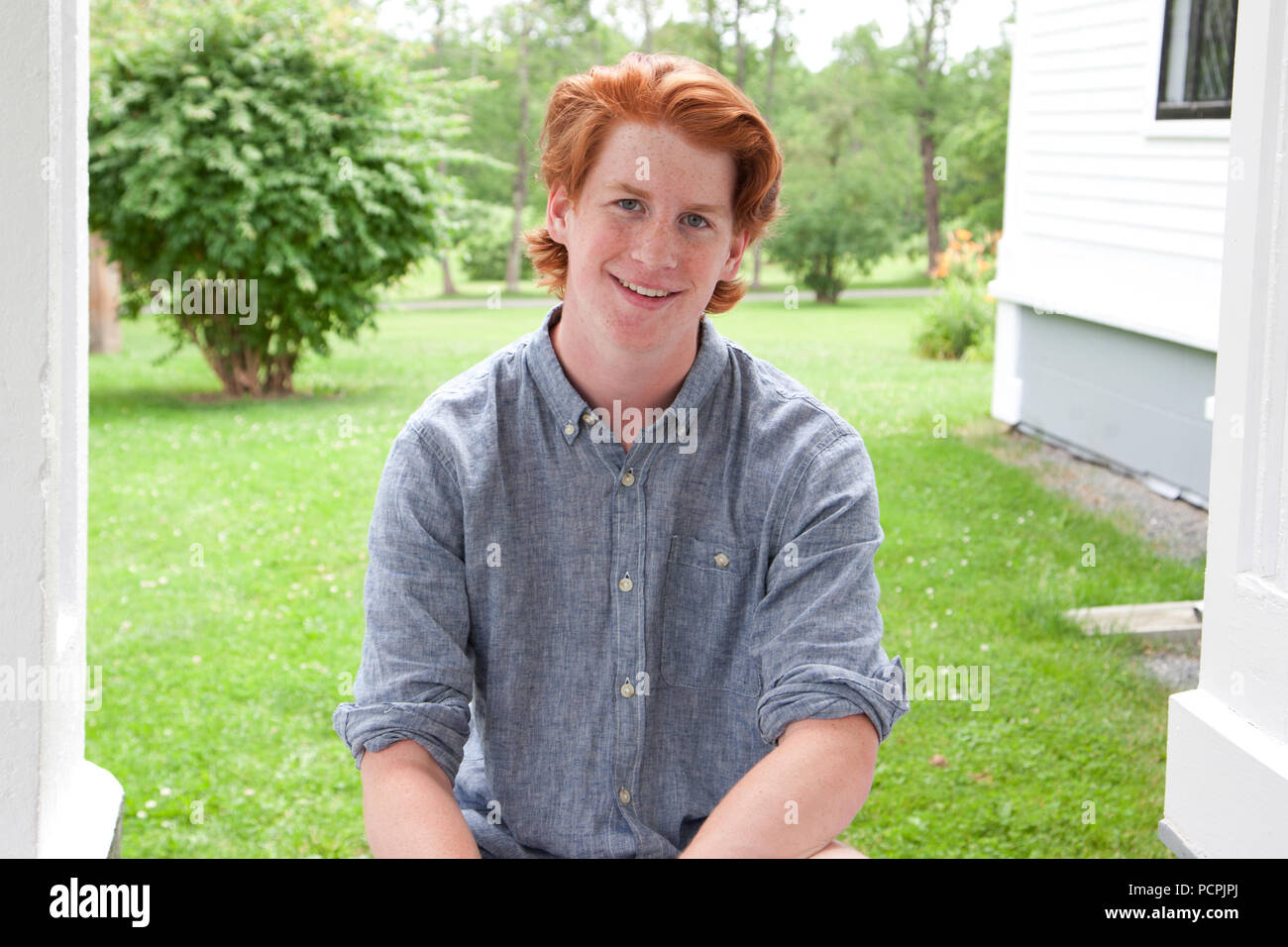 A young high school age teen with ginger hair and freckles poses for a portrait Stock Photo