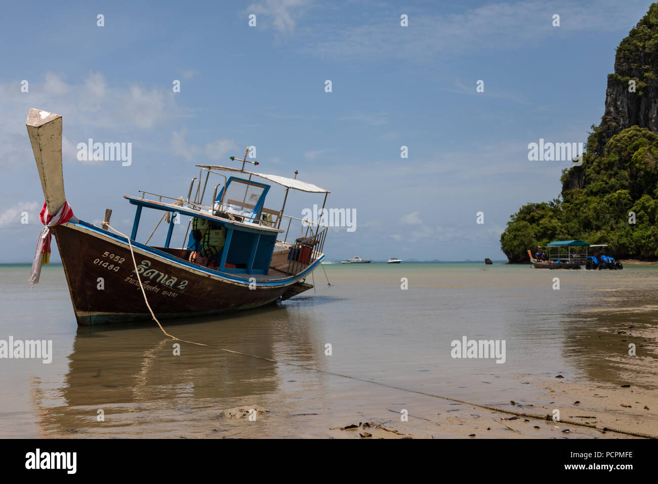Long tail boat beached during low tide at Railay Beach Krabi Thailand Stock Photo