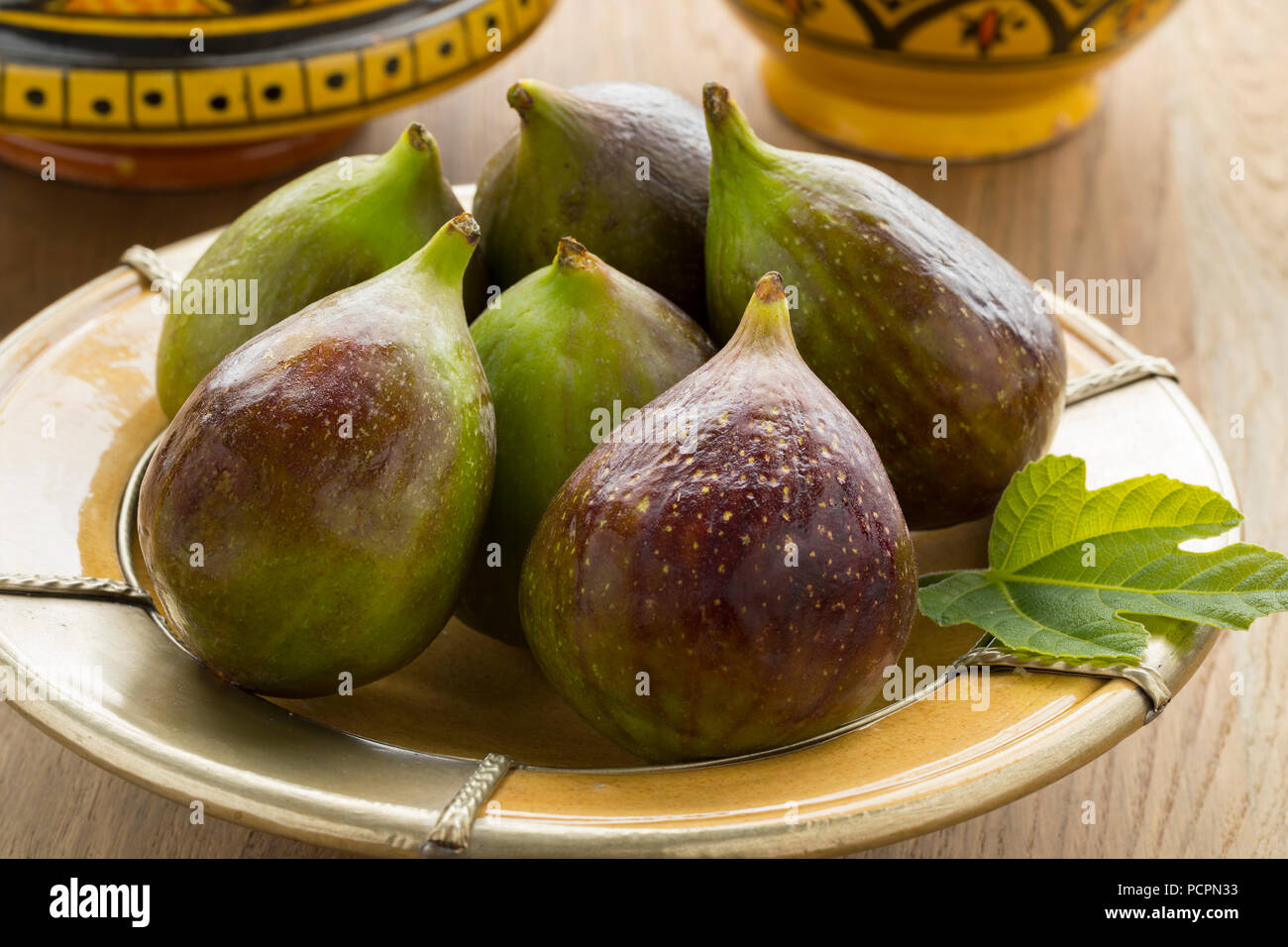 Fresh picked ripe figs and a leaf on a dish for dessert Stock Photo