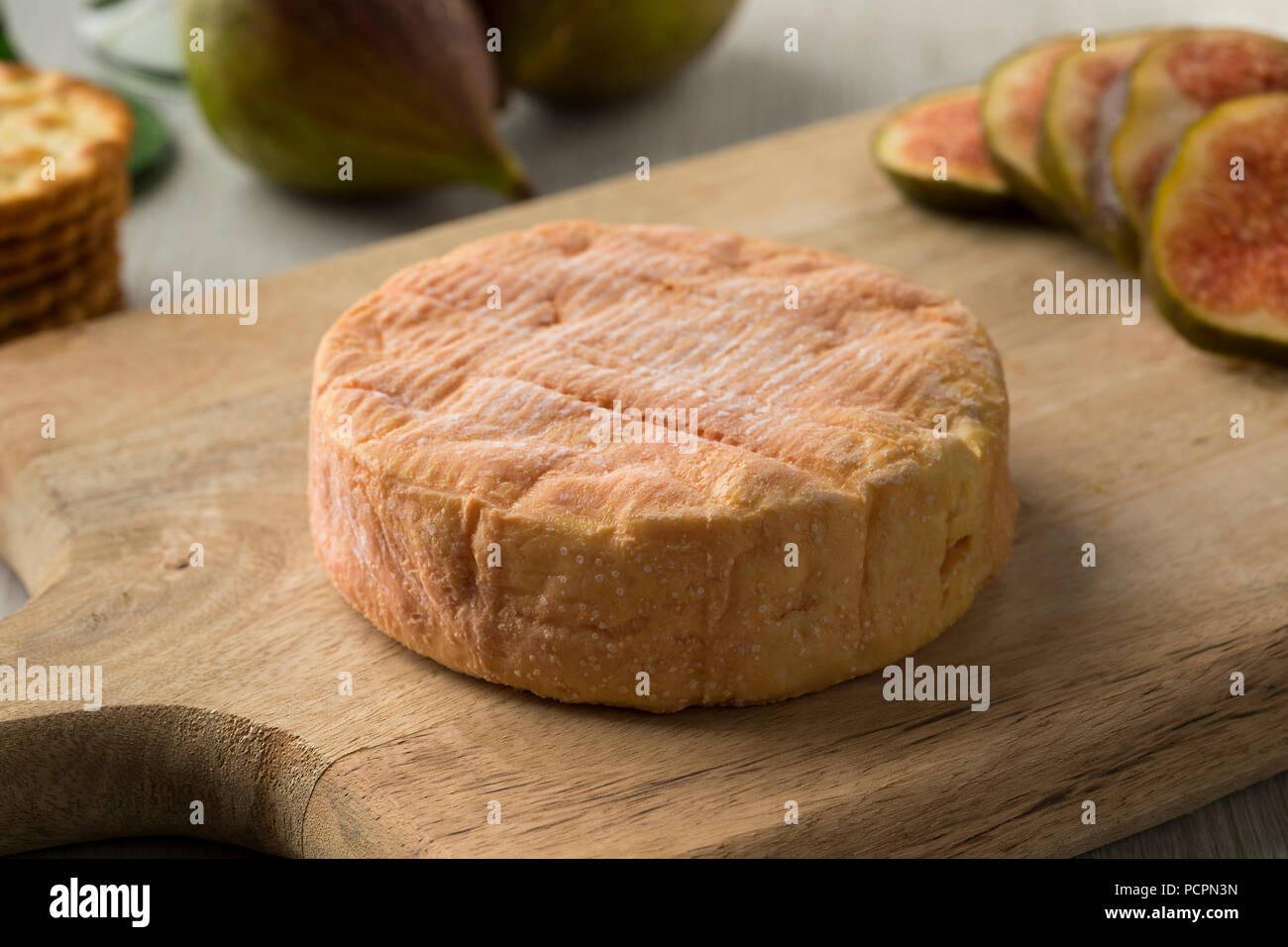 Whole ripe petit Munster cheese close up and fresh figs on the background for dessert Stock Photo