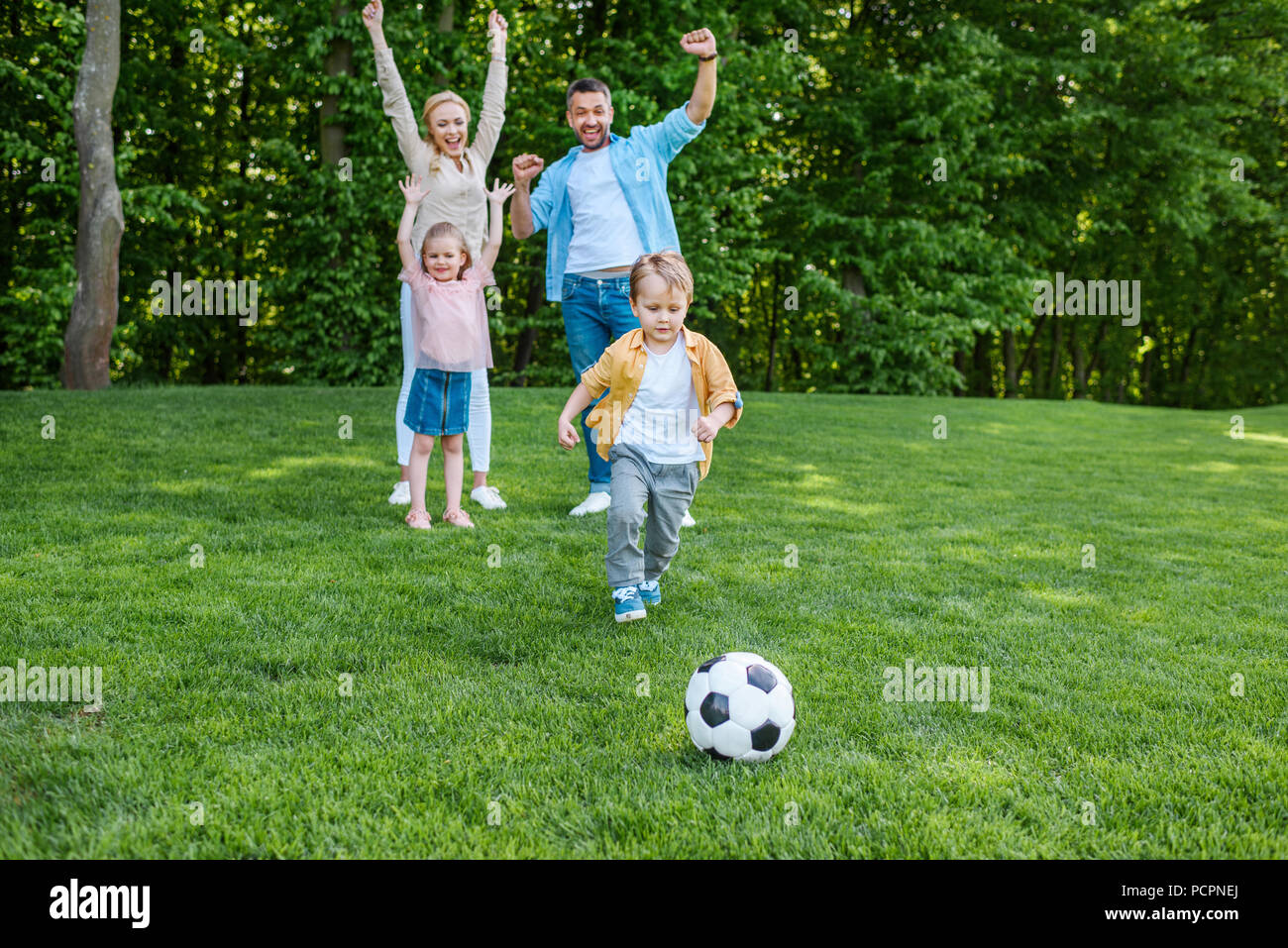 happy family playing with soccer ball in park Stock Photo - Alamy