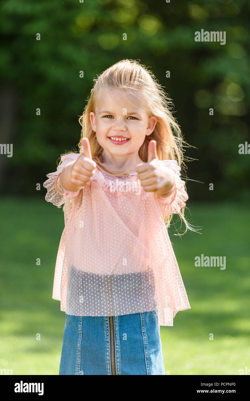 cute little child showing thumbs up and smiling at camera Stock Photo ...