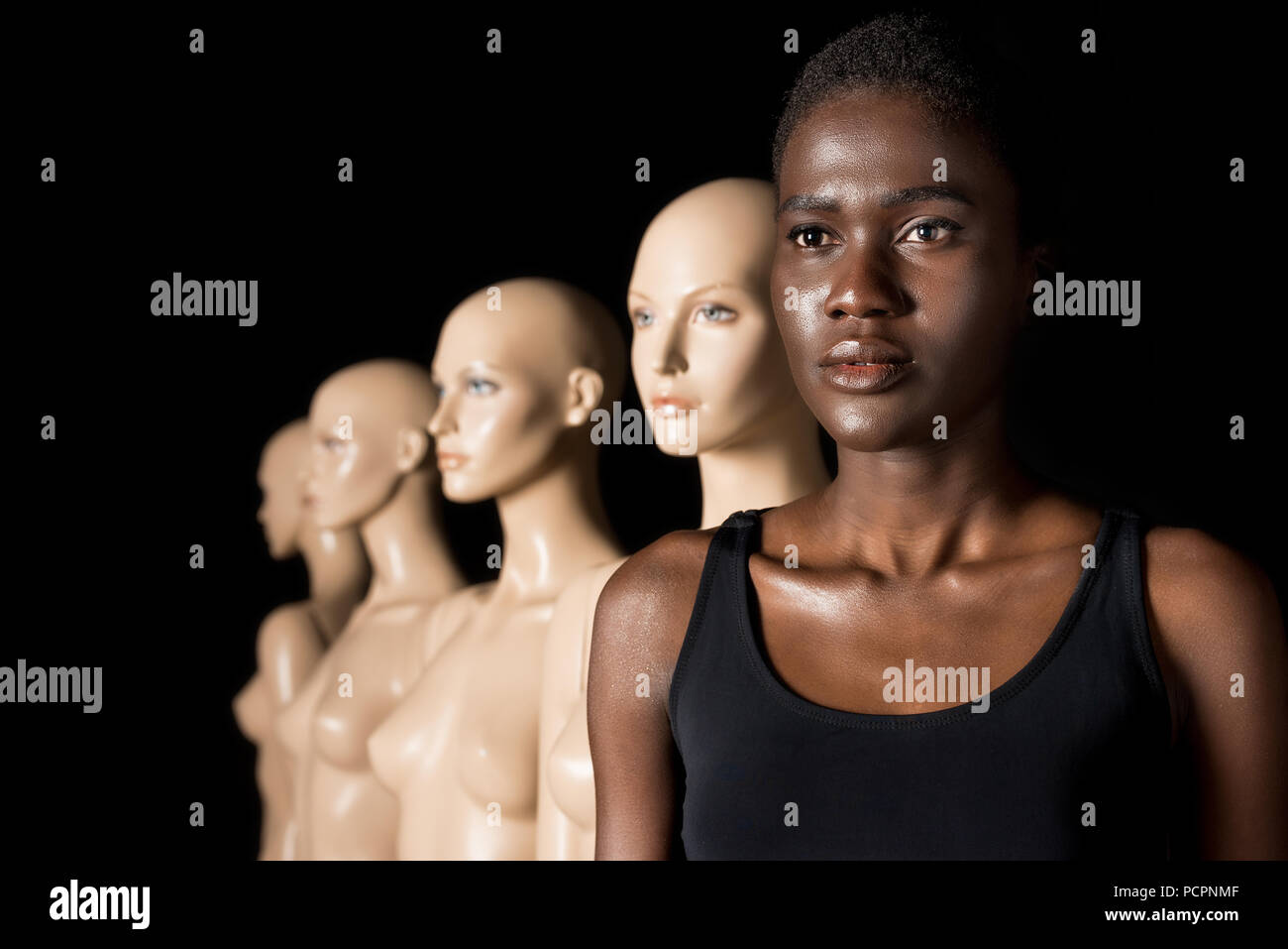 serious african american woman in swimsuit standing in row with