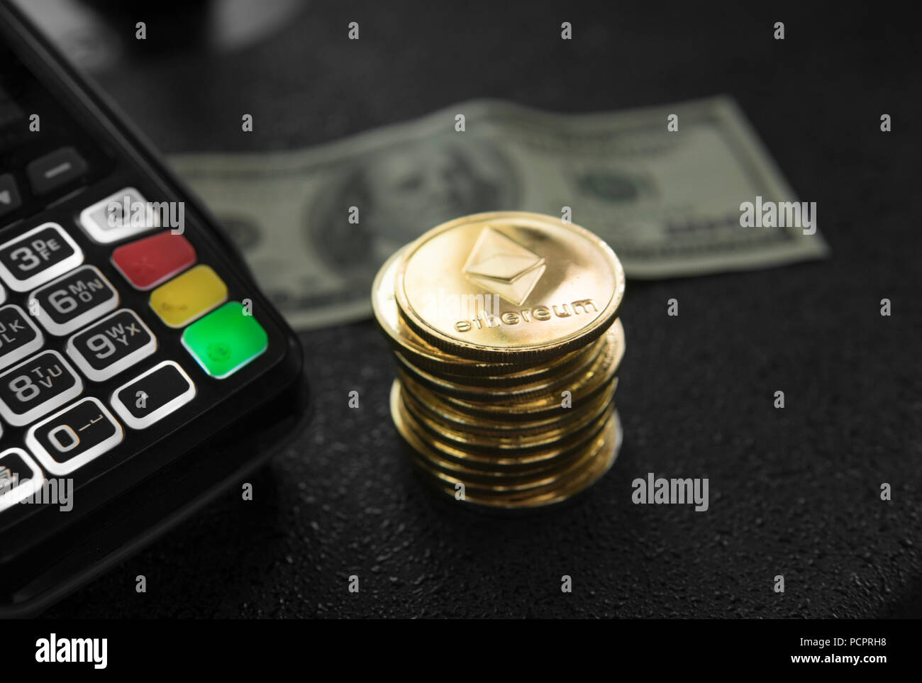 A pile of gold Ethereum coins and POS terminal with a hindred dollar  banknote on a background. Ethereums Cryptocurrency. E-commerce, business,  finance concept, banking and paymant Stock Photo - Alamy
