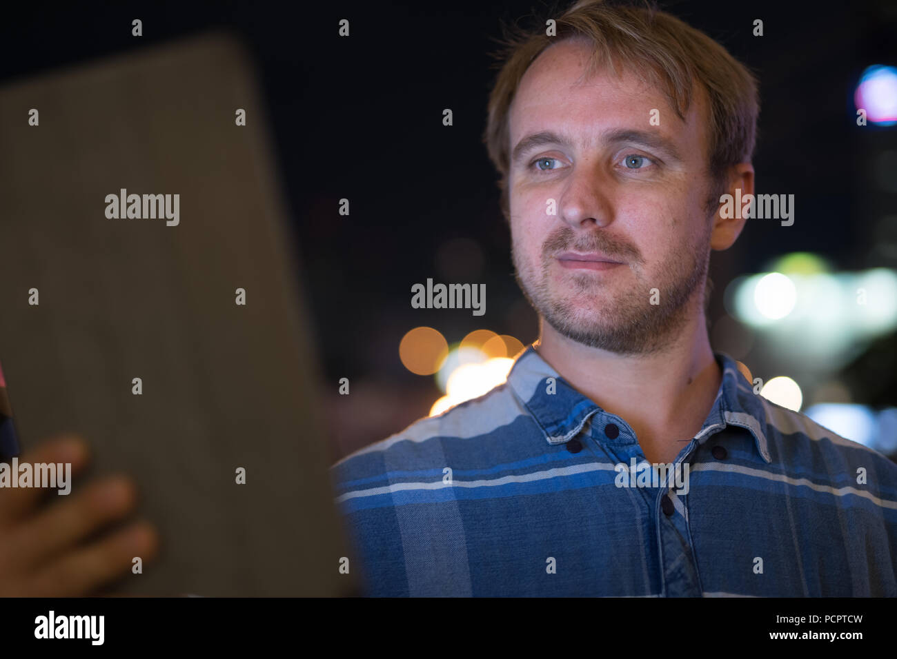 Handsome businessman using digital tablet at night Stock Photo - Alamy