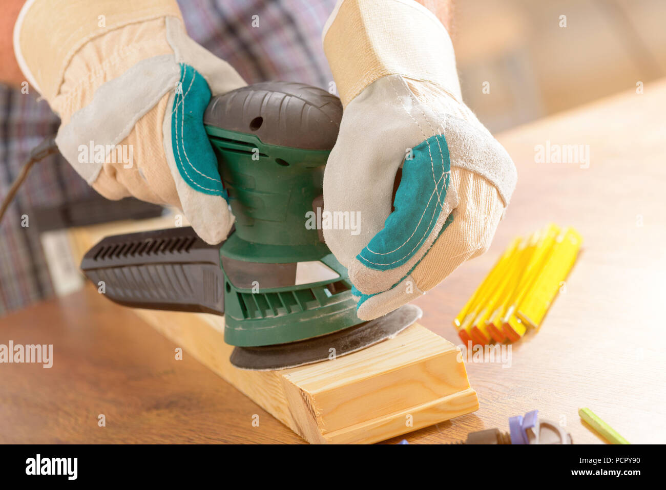 Man sanding a wood with orbital sander in a Stock Photo Alamy