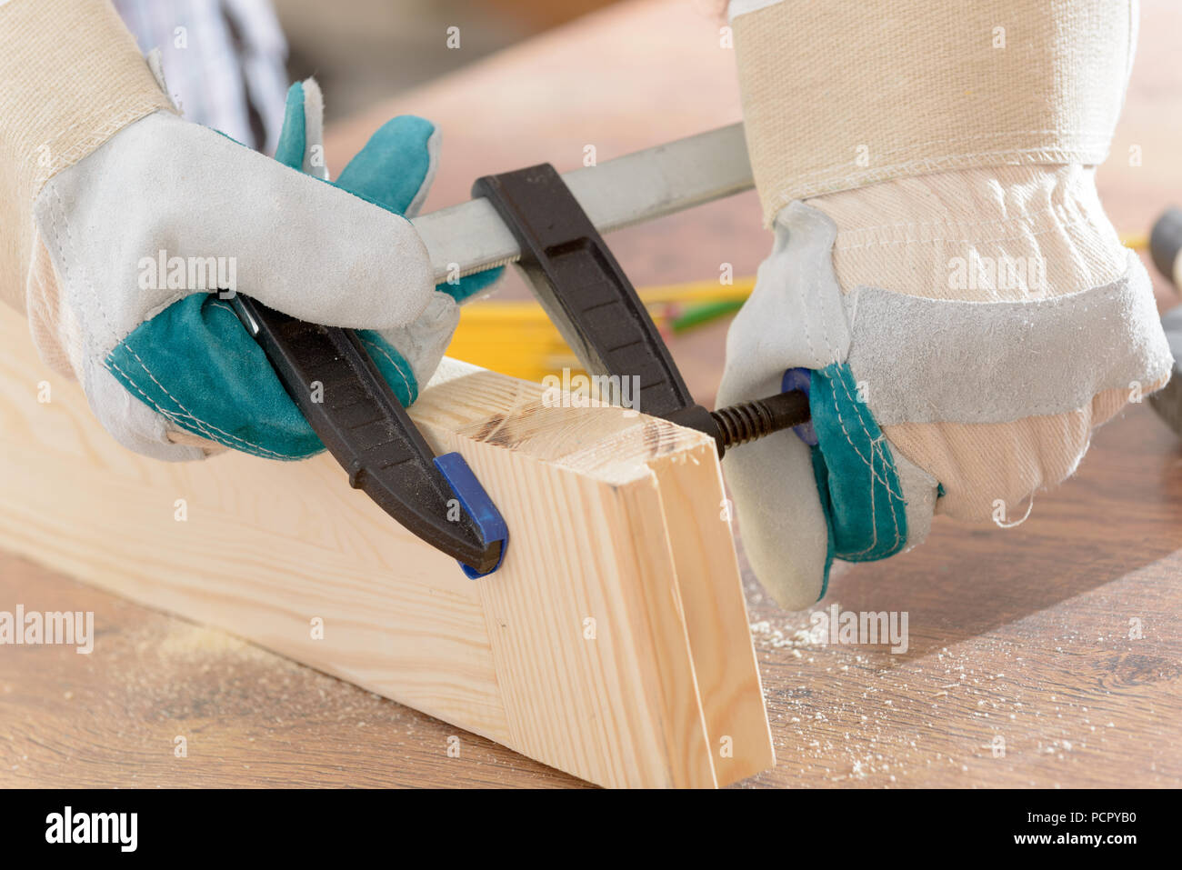 Man carpenter using bar clamp in a Stock Photo Alamy