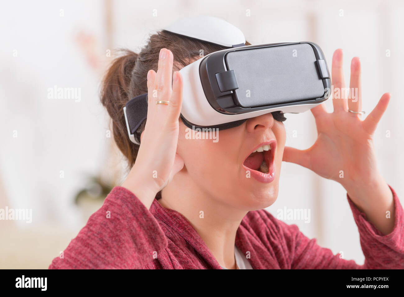Happy woman using virtual reality headset at home Stock Photo - Alamy