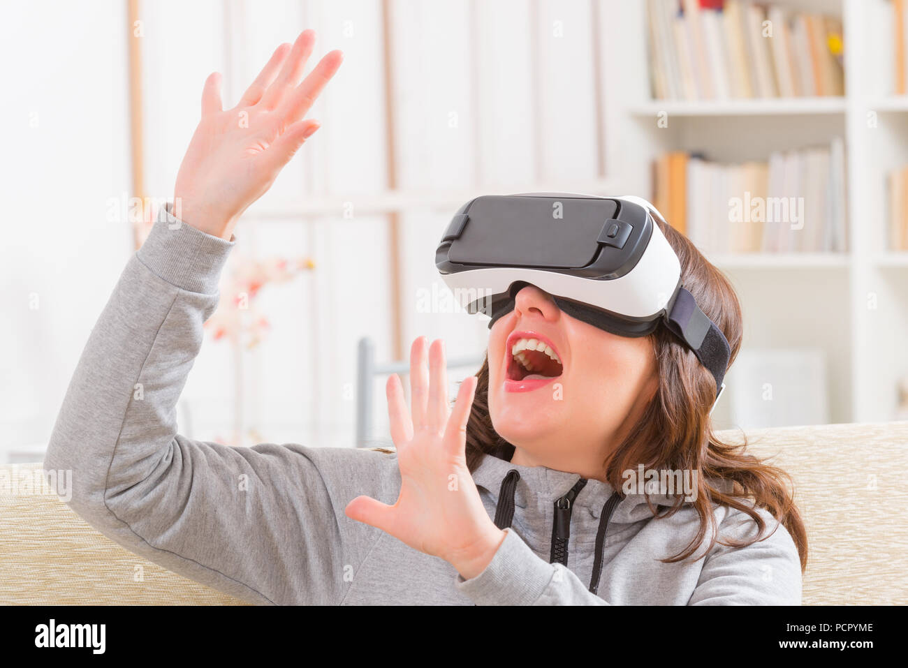 Happy woman using virtual reality headset at home Stock Photo - Alamy