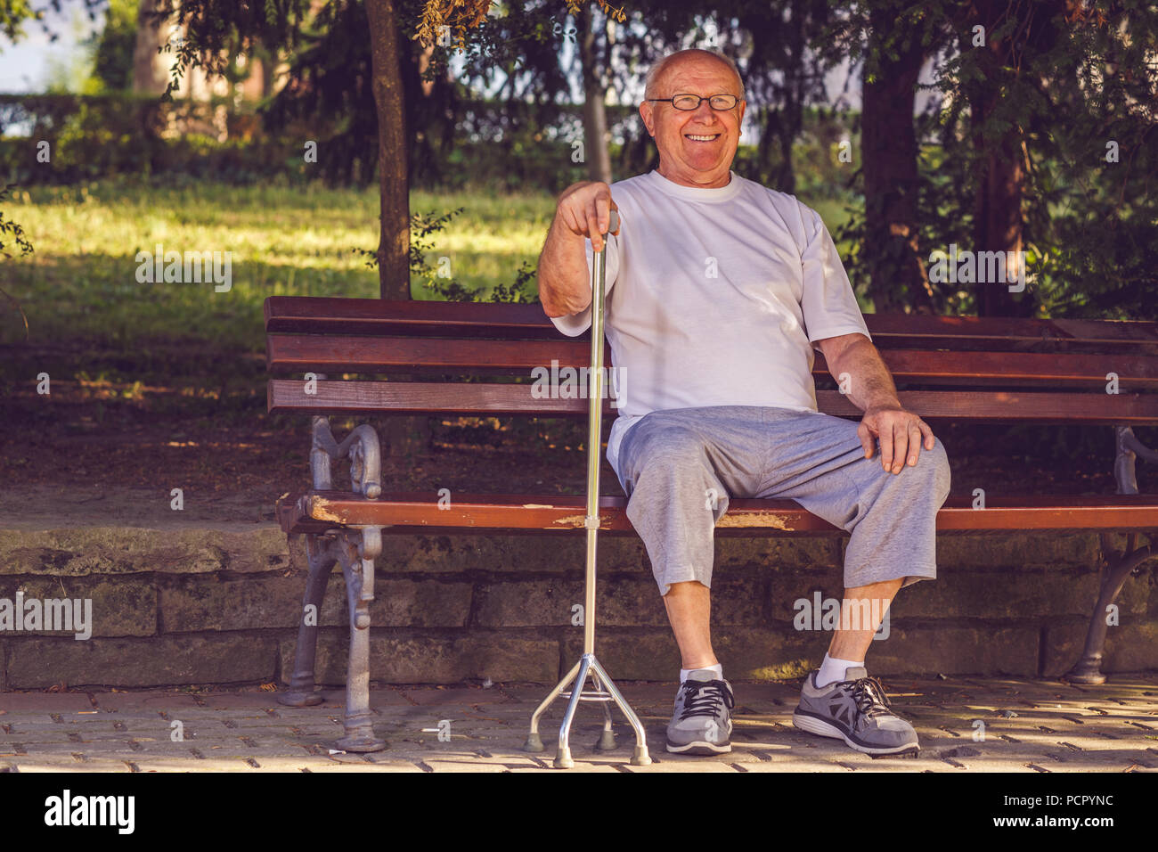 pensioner man with his walking stick in park Stock Photo