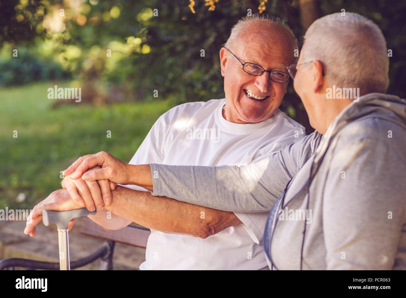 Happy together. Delighted positive pensioner couple looking at each other and smiling while feeling happy together Stock Photo