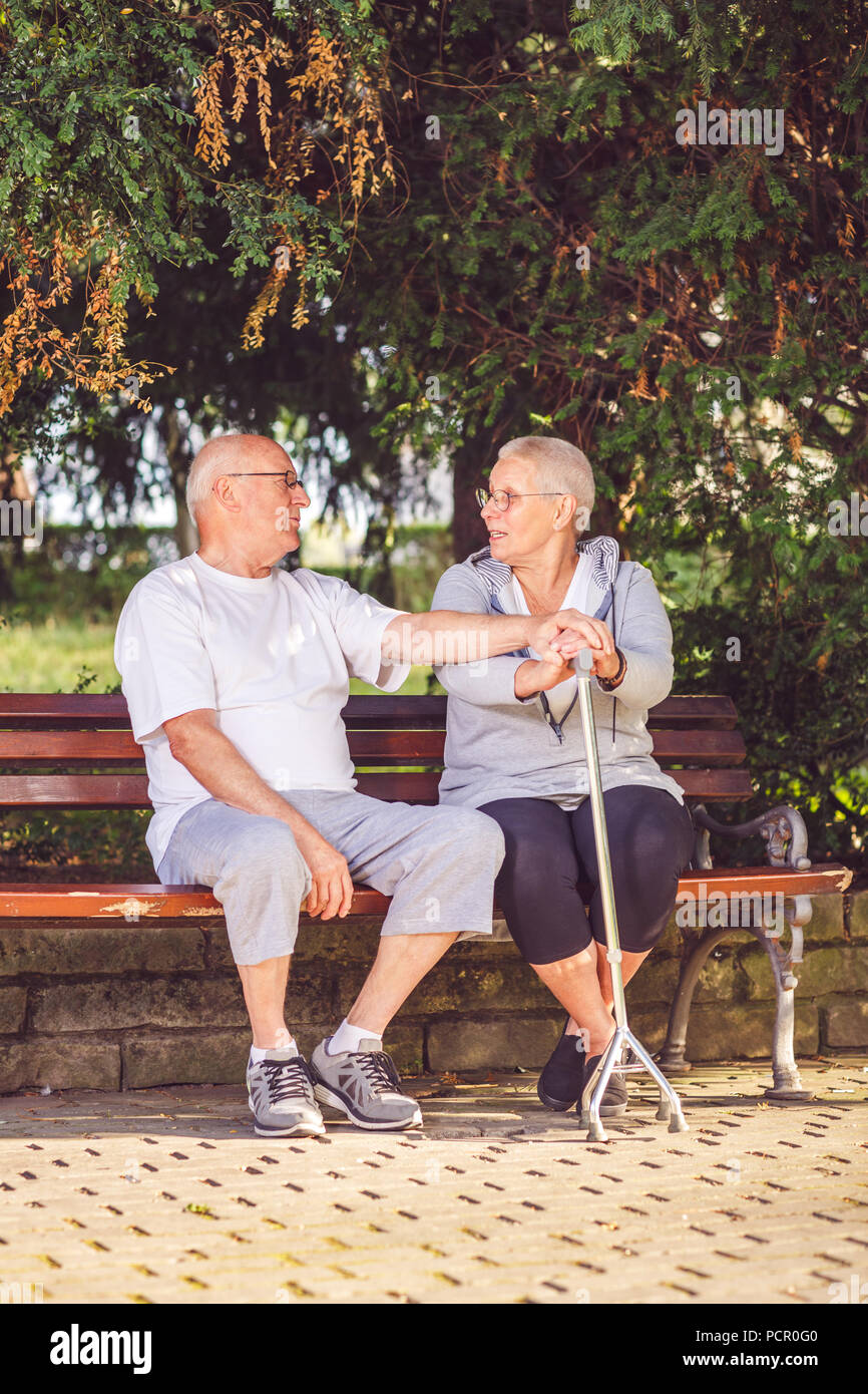 Happy pensioner couple relaxing outdoors on a summer day Stock Photo