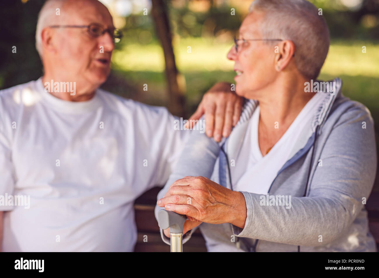 hands of pensioner woman during walk in park on sunny day Stock Photo