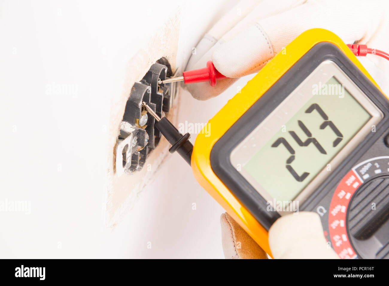 Electrician checking socket voltage with digital multimeter Stock Photo