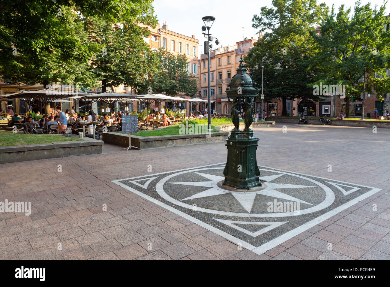 FRANCE, TOULOUSE - JULI 9, 2018: The statue in front od the outdoors terraxes of the place Saint-Georges around dinner time. Stock Photo