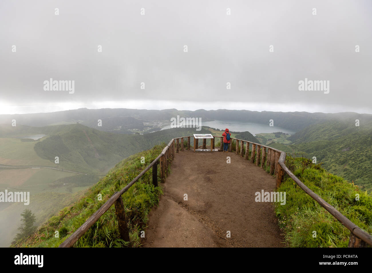 Tourist on Lagoa do Canario Miradouro, viewpoint, in a foggy and rainy day and Santiago Lake and Tourist on Lagoa do Canario Miradouro, viewpoint, in a foggy and rainy day and Santiago Lake and