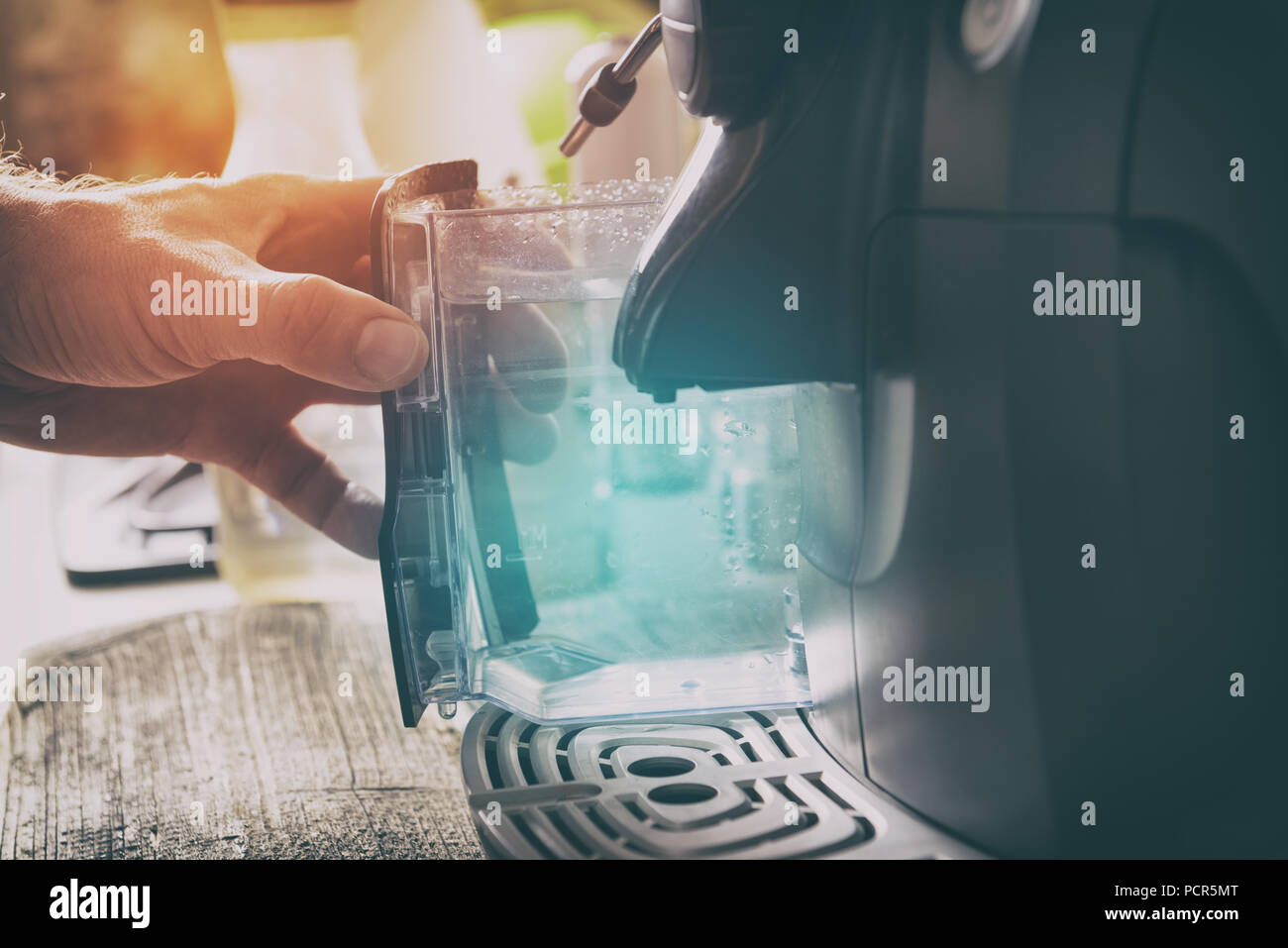Water refill in coffee machine, a container in hand Stock Photo Alamy