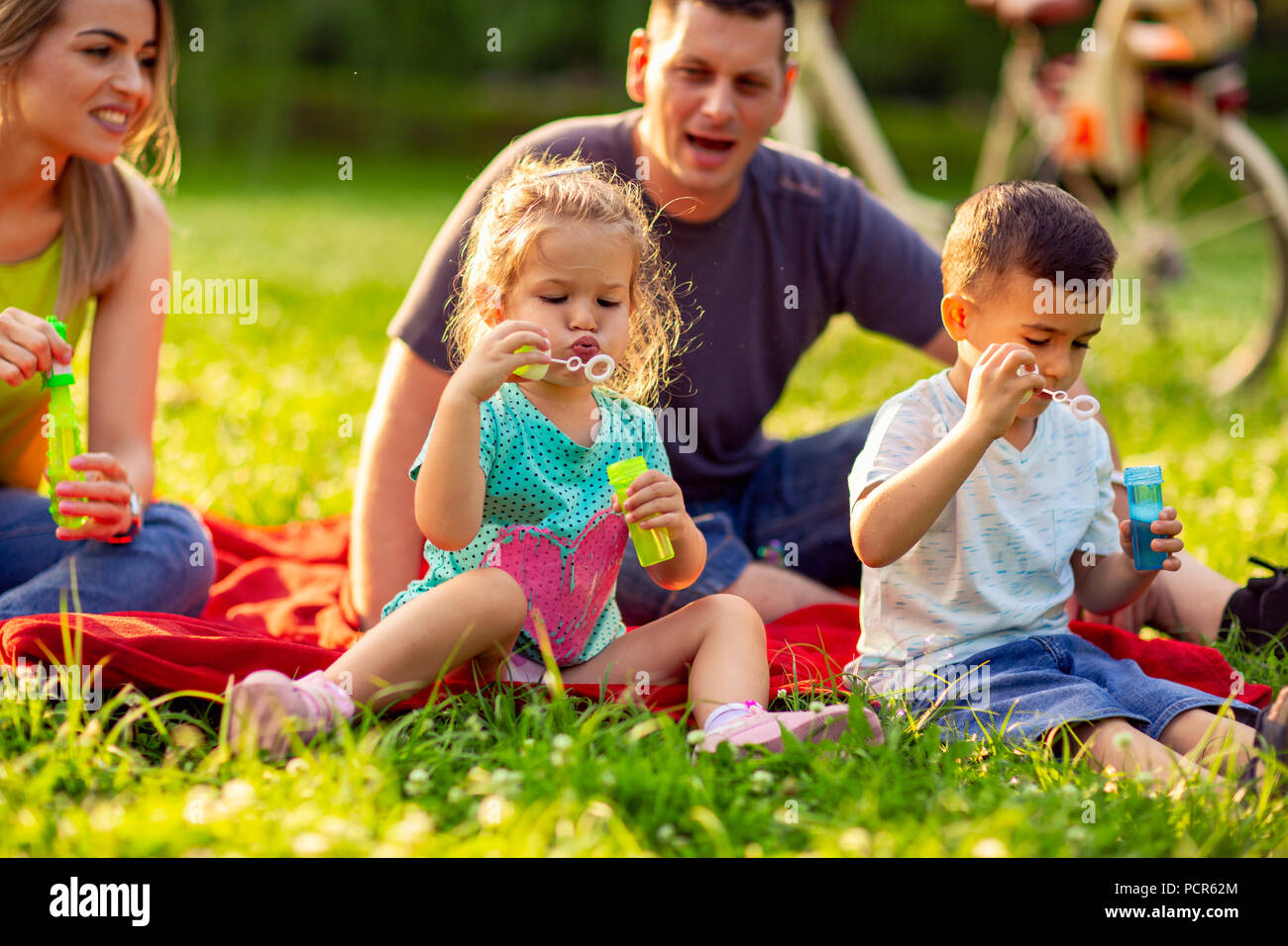 cute children blow soap bubbles outdoor- Happy family in the park ...
