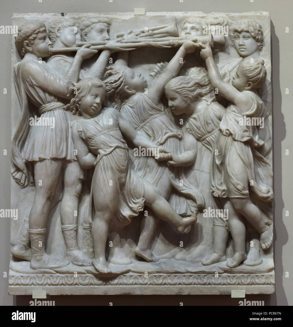 Young dancers and musicians depicted in the marble relief illustrating the Psalm 150 from the Cantoria (singing gallery) designed by Italian Renaissance sculptor Luca della Robbia (1432-1438) for the Sacristy of the Florence Cathedral (Cattedrale di Santa Maria del Fiore), now on display in the Museo dell'Opera del Duomo (Museum of the Works of the Florence Cathedral) in Florence, Tuscany, Italy. Stock Photo