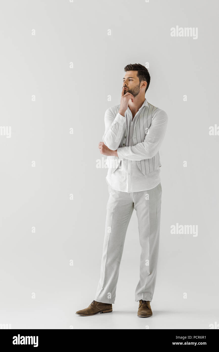 thoughtful man in linen clothes with finger on mouth isolated on grey background Stock Photo