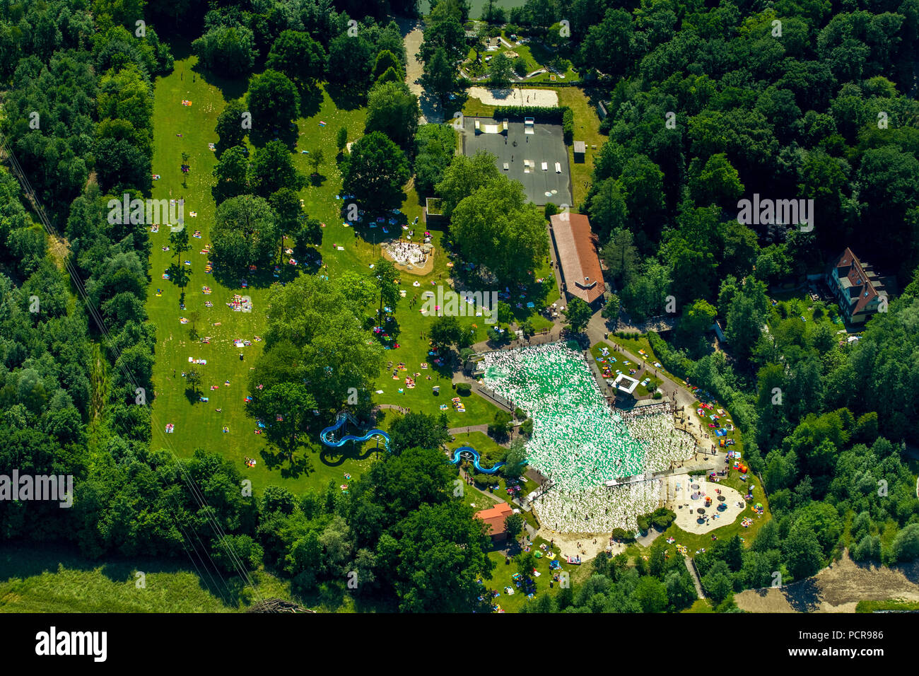 Natural outdoor pool Mettmann, Bathers, full sunbathing areas, summer day, Mettmann, Rhineland, North Rhine-Westphalia, Germany Stock Photo