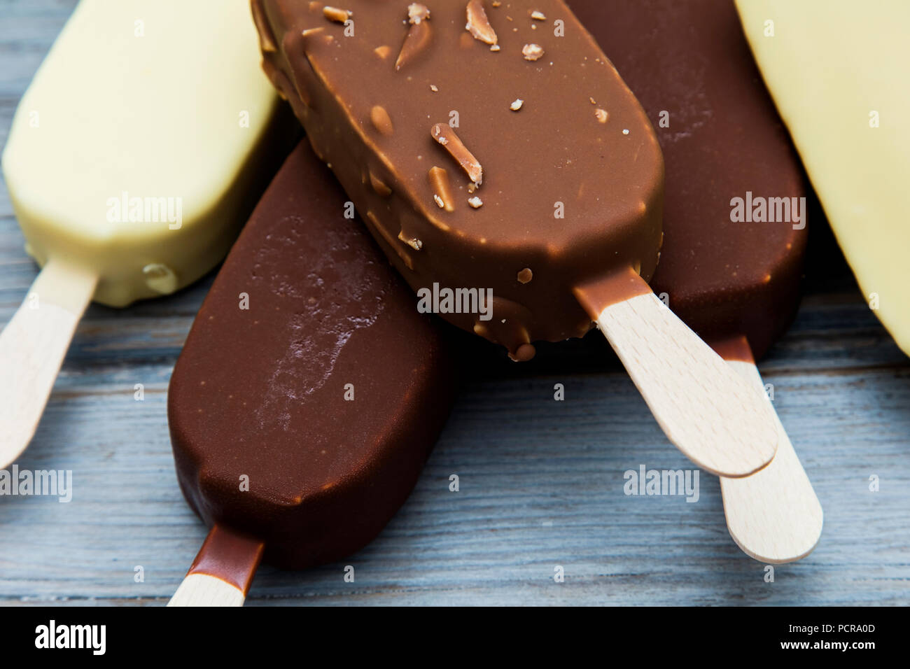 Chocolate ice cream lollies on a wooden background Stock Photo Alamy
