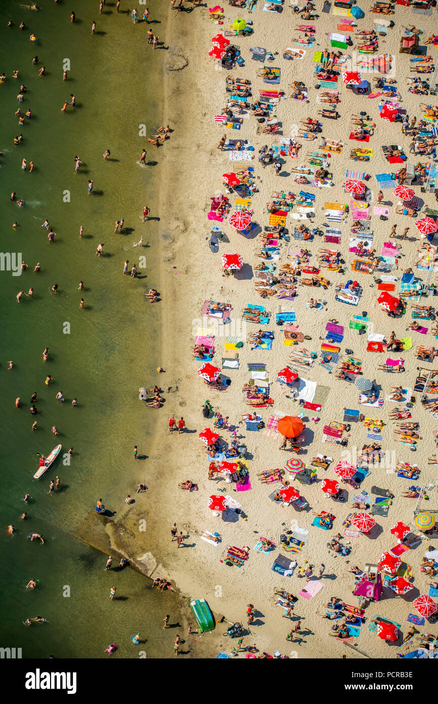 Sundown Beach, bathers on towels, hottest day in spring 2015, Escher Lake, water, red towels, red parasols, white beach, mini-palms and straw huts providing for 'South Sea Feeling' at the Escher Lake in Cologne, bathing lake, Cologne, Rhineland , North Rhine-Westphalia, Germany Stock Photo