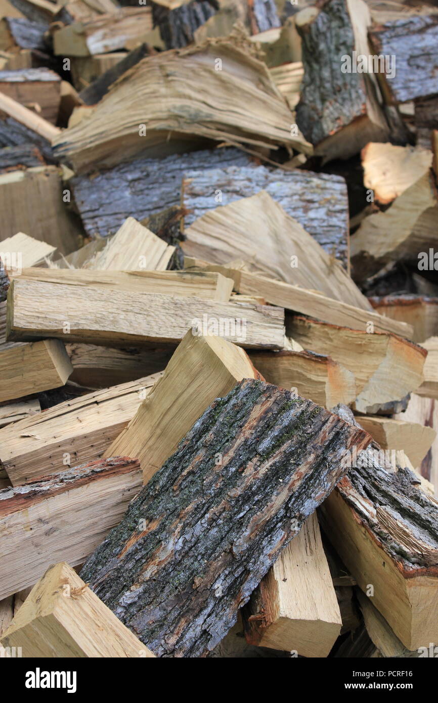 Piles of wood to be split along the grain into firewood logs at the The