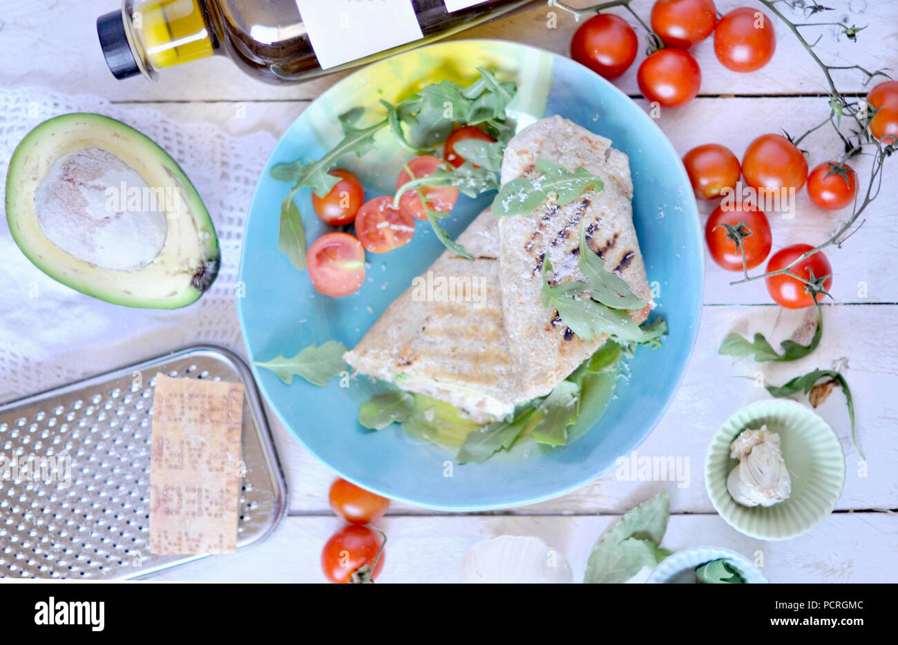 roll of pita bread on the grill. stuffing with fish and salad. avocado