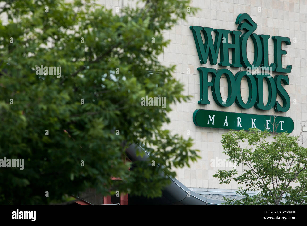 A logo sign outside of a Whole Foods Market grocery store location in